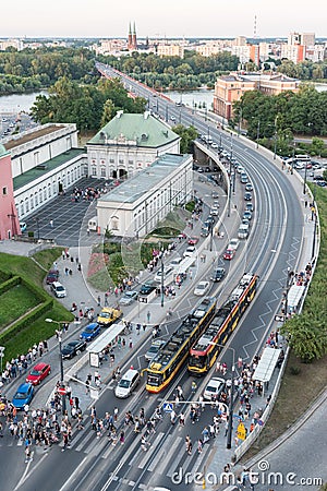 Queues of cars form as more than a hundred people exit trams and cross the road at the Stare Miasto tram stop near Castle Square Editorial Stock Photo