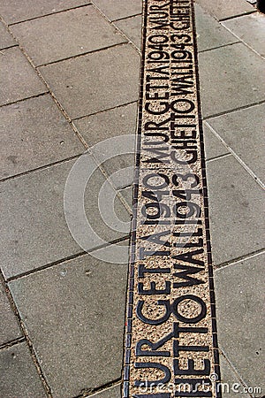 Sign on the ground where the wall of the Jewish Warsaw ghetto was located during the Second World War Editorial Stock Photo