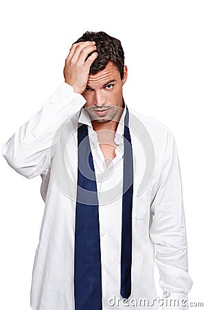 That was a heavy night. A hungover young man wearing a dishevelled shirt and loose tie isolated on white. Stock Photo