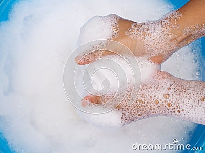 Wash white clothes and soak cloth in laundry detergent water in tub washing. Stock Photo