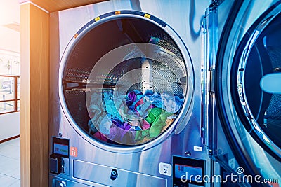 Washed and dried clothes laundry machines in the large laundromat. Stock Photo