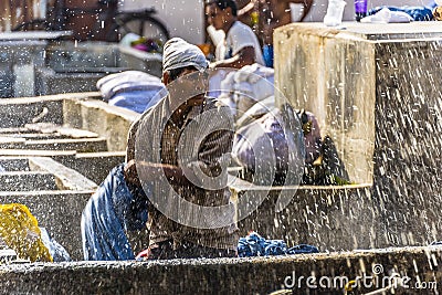 A washer at the Dhobi Ghat in Mumbai wrings his clothing in the Dhobi Ghat in Mumbai Editorial Stock Photo