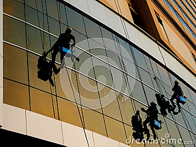 Washers wash the windows mirror of skyscraper silhouette shot Editorial Stock Photo