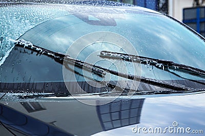 Washing car windscreen with wipers and liquid Stock Photo