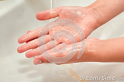 Washing children`s hands under the tap. No COVID-19 Stock Photo