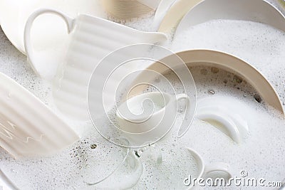 Washing dishes, utensils soaking in kitchen sink Stock Photo