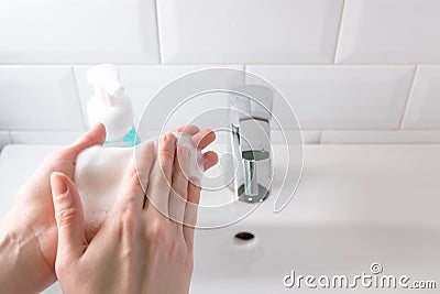 Washing hands with gentle soap foam over the sink in the bathroom, indoors. Concept healthcare Stock Photo