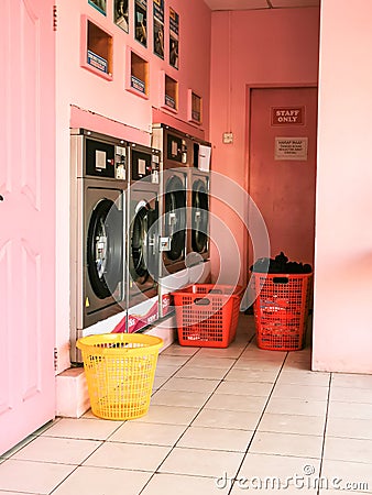 Washing machine and baskets in local self service laundry shop. Selective focus. Stock Photo