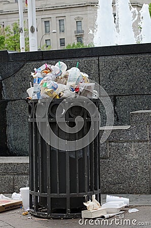 Overflowing trash can on the sidewalk of downtown DC. Concept for garbage, clean up, enviornment, Editorial Stock Photo