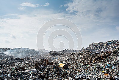 Wastage at the garbage dump full of smoke, litter, plastic bottles,rubbish and trash at tropical island Stock Photo