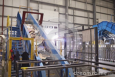 Waste cardboard entering recycling plant on a conveyor belt Stock Photo