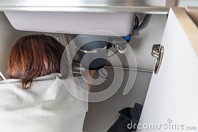 Waste disposal leak under a sink, broken garbage chopper Stock Photo