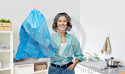 Smiling woman holding plastic trash bag with waste Stock Photo