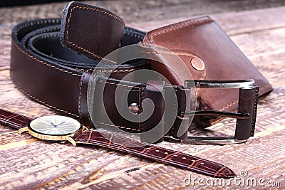 Watch, leather belt and wallet, bottle with cologne on wooden background. Stylish mens business accessories. Stock Photo