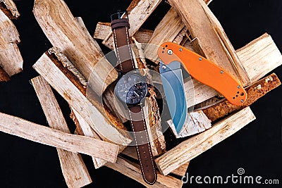 Watch mens on wood. Black dial. Knife with orange handle Stock Photo