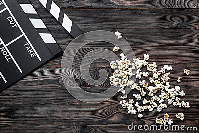 Watching the film. Movie clapperboard and popcorn on wooden table background top view copyspace Stock Photo