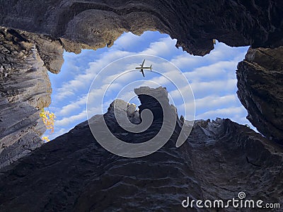 Watching the flight of the plane from the window of the cave Stock Photo