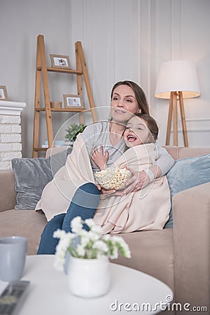 Delighted mother and daughter eating popcorn Stock Photo