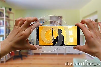 Watching online concert at home by smartphone. Live stream music video Stock Photo