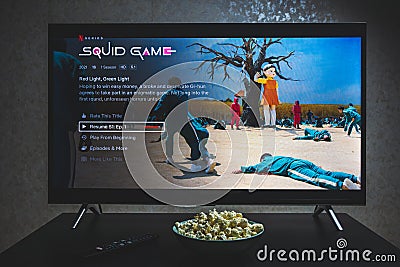 Watching Squid game show on TV. Squid game is a South Korean survival drama television series streaming on Netflix Editorial Stock Photo