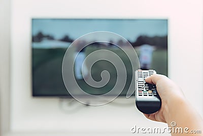 Watching Television Golf Sport program with hand remote control Stock Photo