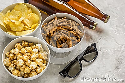 Watching TV with chips, beer and glasses on stone background Stock Photo