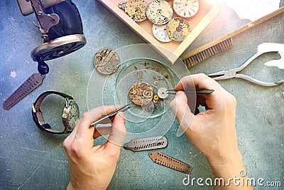 Watchmaker at work in workshop. Flat lay. Workplace of watch repairer. Process of repair mechanical watches. Stock Photo