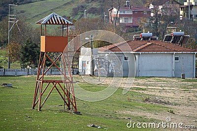 Watchtower for lifeguards on a meadow of green grass next to the sand Stock Photo