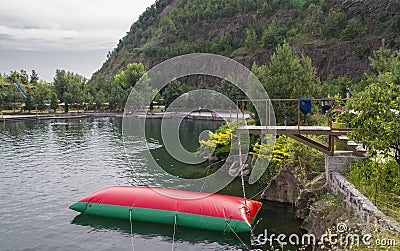 Water attraction trampoline in the mountain pool Stock Photo