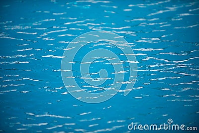 Water background. Blue water, ripples and highlights. Texture of water surface and tiled bottom. Stock Photo