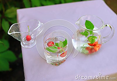 Water with berries on violet table. Summer drinks. Refreshing background. Colourful food. Restaurant menu Stock Photo