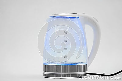 water boils in a transparent electric kettle on a white background. macro. Stock Photo