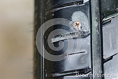 Screw nail on tyre Stock Photo