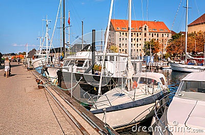 Water chanel with people walking, moored yachts and old brick houses Editorial Stock Photo