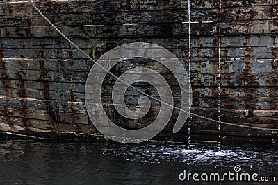 water comes out of a big wooden fishing boat from Indonesia Stock Photo