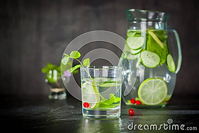 Water detox in a glass jar and a glass. Fresh green mint and berries. A refreshing and healthy drink. Stock Photo