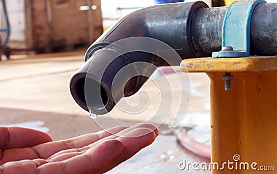 Water dropping from tap to hand someone. Stock Photo