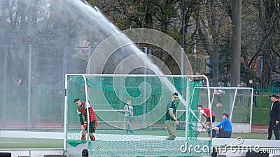 Water flow from a hose waters the field hockey stadium Editorial Stock Photo