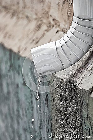 Water flowing out the end of an eavestrough Stock Photo