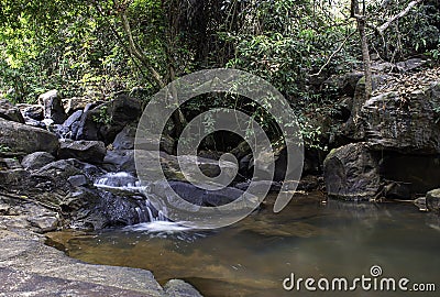 The water flowing over rocks and trees down a waterfall at Khao Ito waterfall , Prachin Buri in Thailand Stock Photo