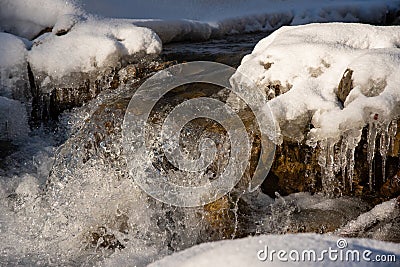 Water flowing in rapids over stone, in the winter mountains Stock Photo