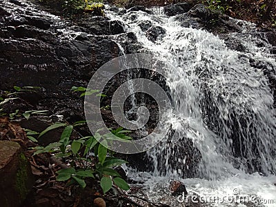 Water flows from a height through rock crevices Stock Photo