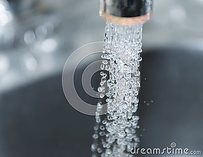 Water flows from the kitchen faucet. Stock Photo