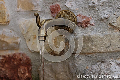 Water fountain and wall made of stones Stock Photo