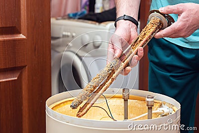 The water heating element of the boiler is covered with sediment and limescale. Boiler repair and maintenance Stock Photo