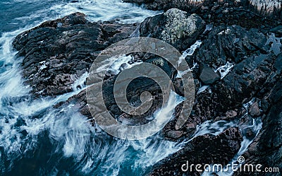 Water hits black rocks Stock Photo