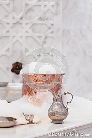 Water jar, towel and copper bowl with soap foam in turkish hamam. Traditional interior details Stock Photo