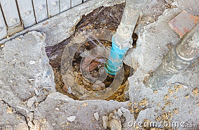 Water leaks from underground blue pipes Stock Photo
