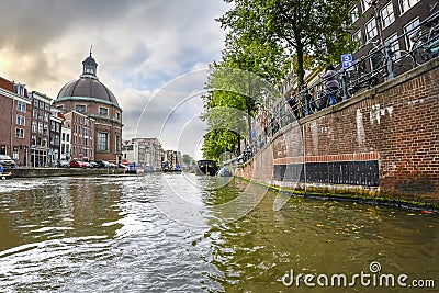 Water level view from the Singel canal in Amsterdam, Netherlands with the Round Lutheran church or Ronde Lutherse Kerk in view Editorial Stock Photo