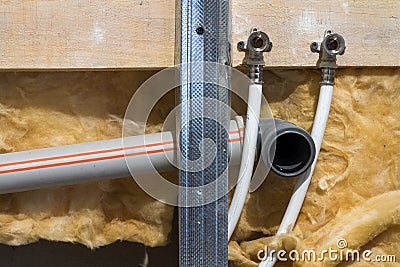 Water pipes made of polypropylene in the wall, plumbing in the house. Installation of sewer pipes in a bathroom of an apartment in Stock Photo